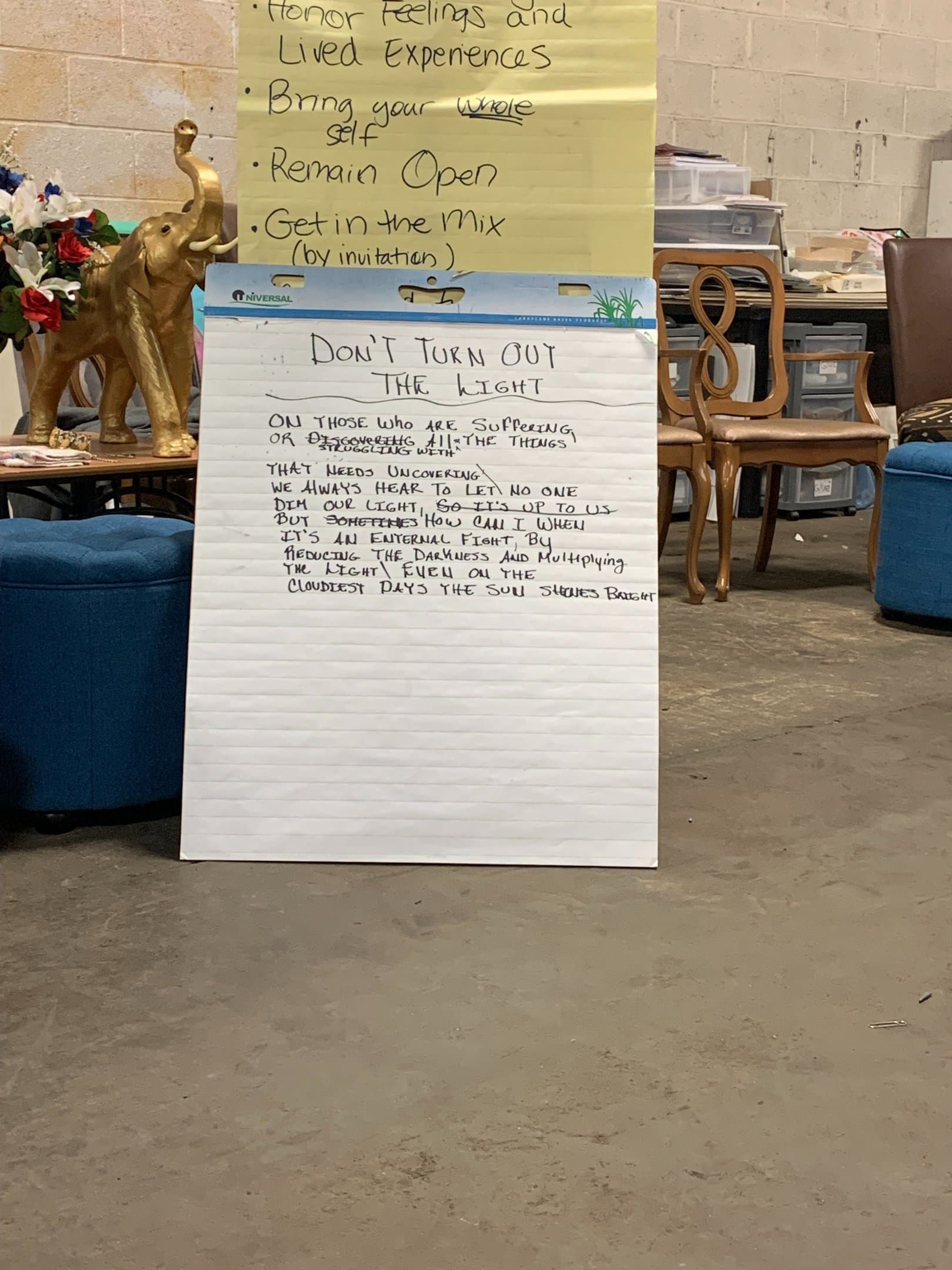 A handwritten collective poem and session themes displayed on easel pads