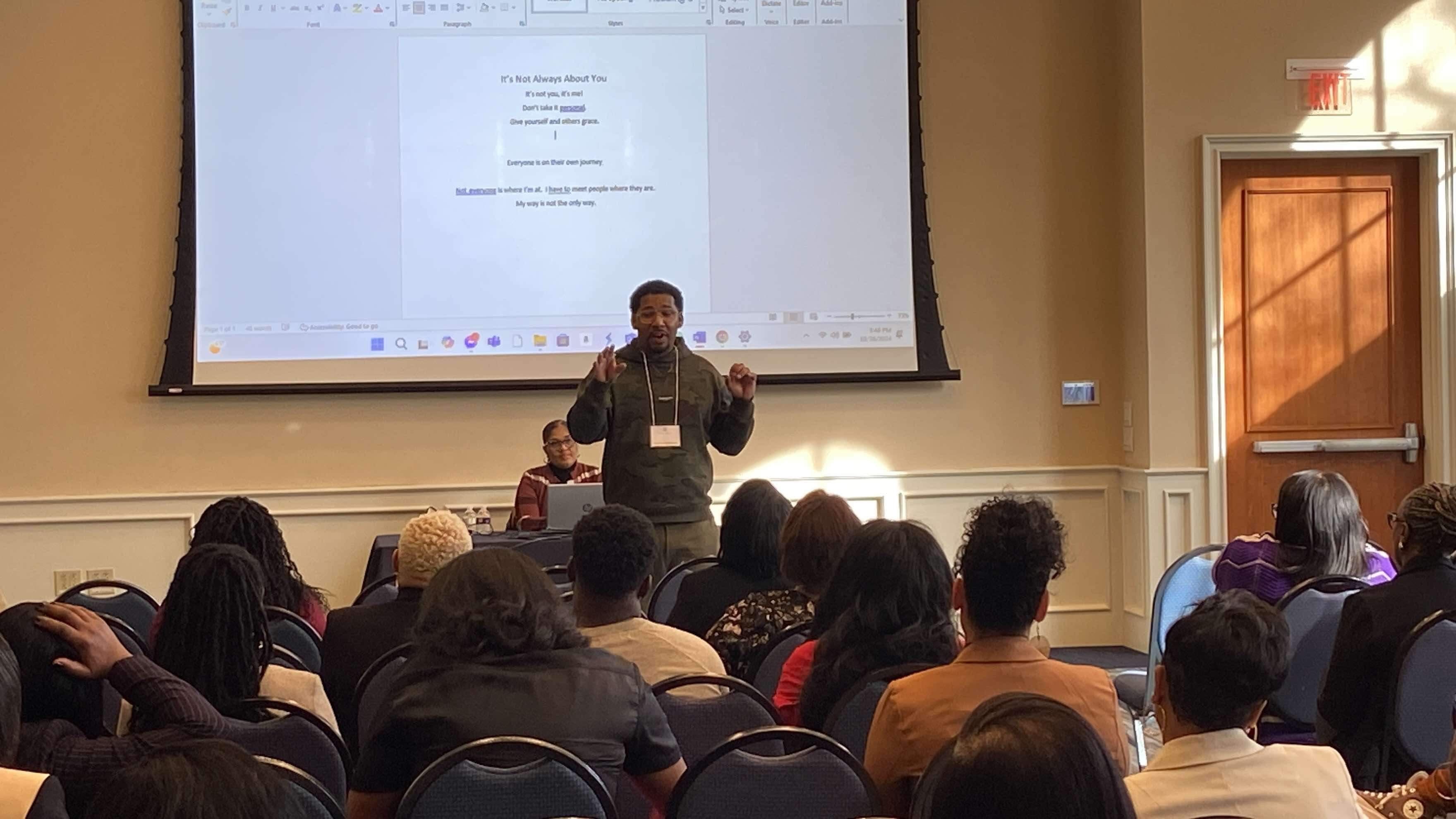 A Poetry Clinic in progress with Wesley Robinson facilitating for a seated group